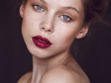 a dramatic makeup with a bold fuchsia lip, highlighted skin, and a touch of brown eyeshadow