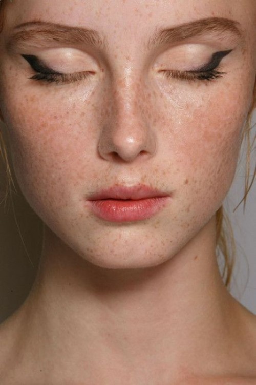 a creative makeup with a kiss-effect pink lip, eyeliner and accented eyebrows plus shiny and highlighted skin