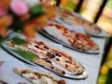 a casual pizza bar with a simple table and pizzas plus bright florals for decorating