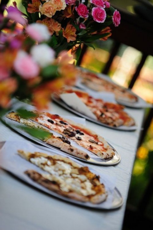 a casual pizza bar with a simple table and pizzas plus bright florals for decorating