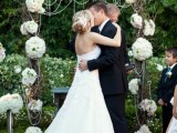 a vine wedding arch decorated with white hydrangeas and crystals is a very cool idea