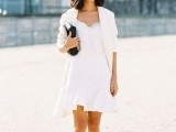 a white A-line mini dress with a lace neckline and ruffle skirt, white oversized blazer and checked shoes plus a black bag