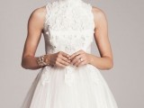 a sleeveless A-line wedding dress with lace appliques and a pleated lace skirt plus a turtle neckline