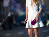 a statement a-line plain mini wedding dress with lace sleeves and a plunging neckline covered with lace, nude heels and a fuchsia clutch for a bold look