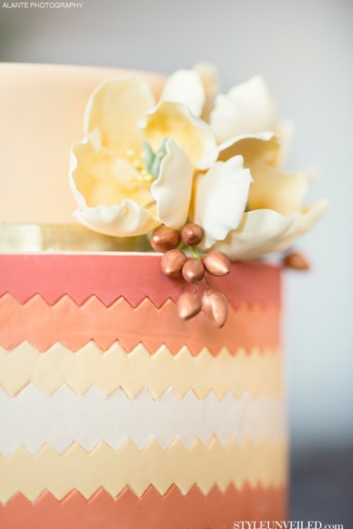 a bright wedding cake with mauve, yellow and orange stripes, with sugar blooms that match in color is a creative idea for a spring or summer wedding