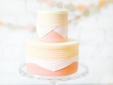 a bright yellow, white and coral wedding cake with a pretty bunting cake topper is a lovely idea for spring or summer
