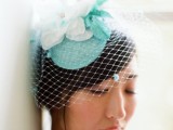 a small and lovely bridal hat in white and mint, with fabric blooms and foliage and a small birdcage veil is amazing