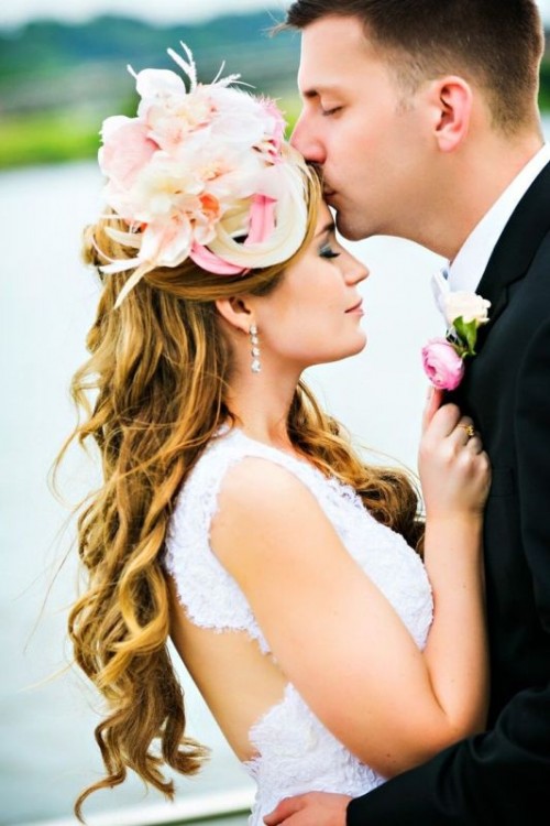 a quirky neutral and pink bridal hat showing off some floral designs and feathers is a gorgeous idea for a romantic bride