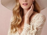 a neutral wide-brim hat with white fabric blooms on top is a chic and stylish idea for a bride who loves vintage