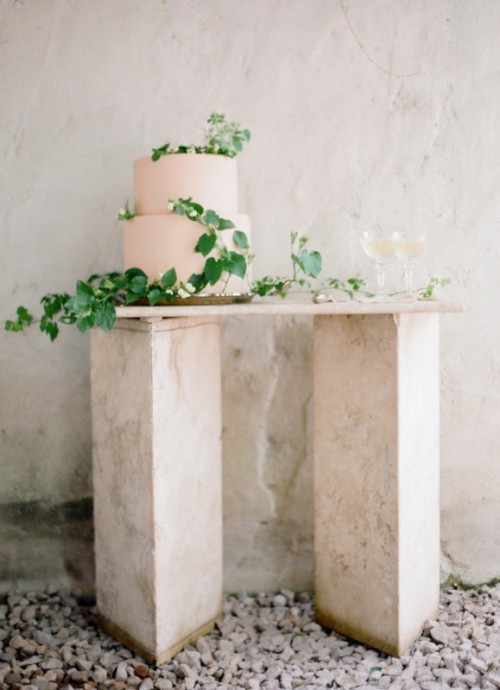 a tender blush wedding cake decorated with greenery for a spring or summer wedding