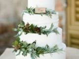 a white textural wedding cake decorated with greenery, berries and a little wedding sign will fit a modern rustic wedding