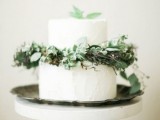 a white textural wedding cake decorated with various greenery and leaves is ideal for a woodland wedding