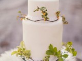 a white minimalist wedding cake with foliage and berries is a chic idea for an elegant modern wedding