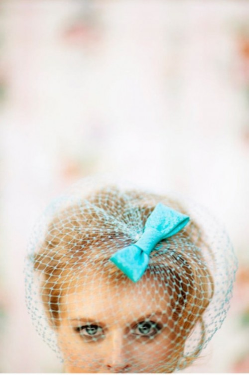 a long blonde pixie with a bold blue birdcage veil with a bow is an eye-catchy retro or vintage inspired look