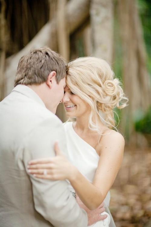 a messy wavy and curly side updo with a volume on top is a more relaxed type of hairstyle for an effortless bride
