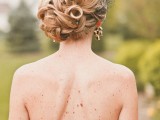 a refined curly, twsited and braided side updo accented with a tiny veil for completing a vintage bridal look