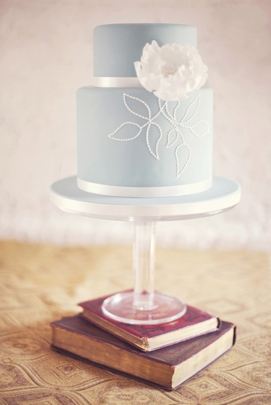 A beautiful powder blue wedding cake with white decor and a large sugar bloom is a tender and sweet idea to try