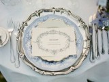 an elegant powder blue wedding place setting with a silver charger, chic cutlery and a powder bue tablecloth on the table