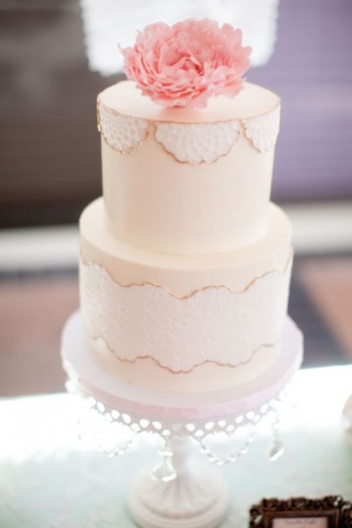 a vintage-inspired bridal shower cake with a fresh bloom on top