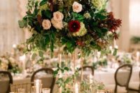 a bold and lush floral wedding centerpiece in blush, burgundy and green blooms and foliage of various shades