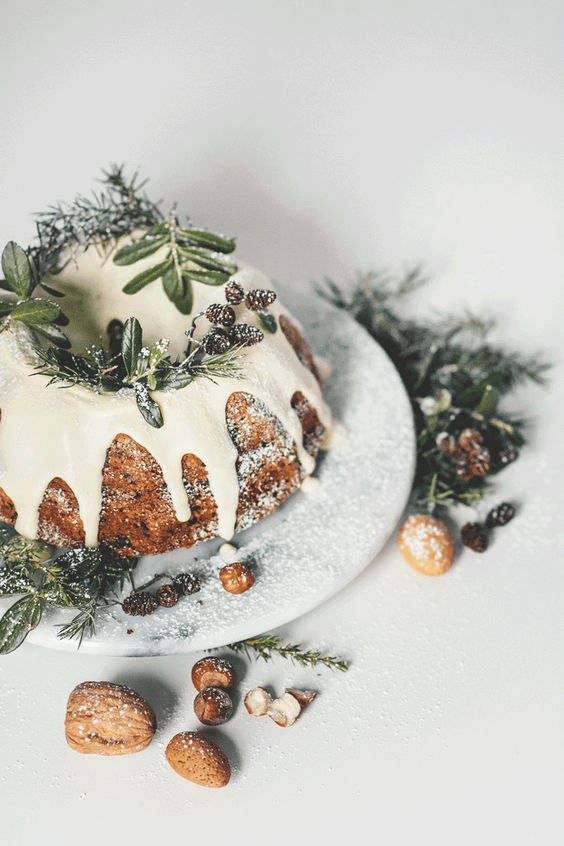 a bundt Christmas cake with dripping, evergreens, pinecones and nuts is a hint to traditions and a nice alternative to a usual cake