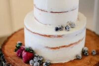 a frosty wedding cake topped with sugared and fresh berries is ideal for a rustic winter wedding