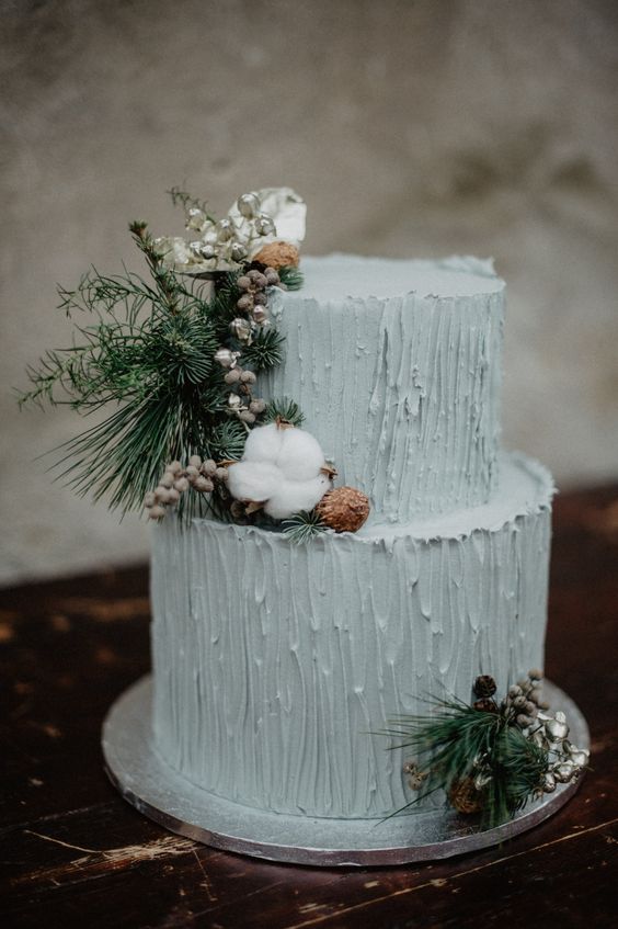 a mint blue textural wedding cake decorated with pinecones, cotton, evergreens, berries is a lovely idea for a winter wedding