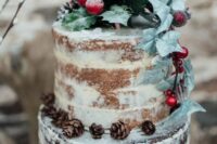 a naked two color wedding cake decorated with greenery, evergreens, pinecones, berries is a lovely idea for a winter wedding