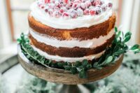 a naked wedding cake topped with sugared cranberries and greenery is a great idea for a winter wedding