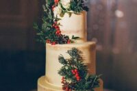 a naked wedding cake with evergreens, greenery, berries and white blooms is a lovely idea for a Christmas wedding