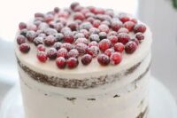 a semi naked wedding cake topped with sugared cranberries is ideal for a cozy winter celebration