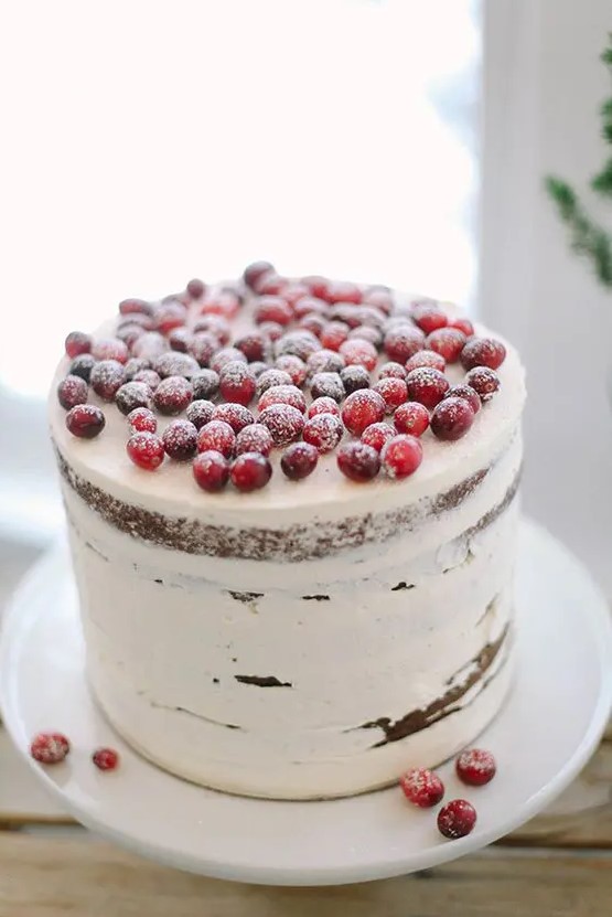 a semi naked wedding cake topped with sugared cranberries is ideal for a cozy winter celebration