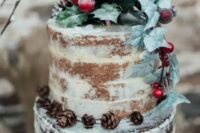 a semi-naked wedding cake with a vanilla and chocolate part, with leaves, pinecones and berries for a winter wedding