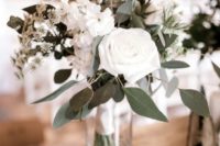 a stylish winter wedding centerpiece of white blooms, greenery and thistles always works for any wedding