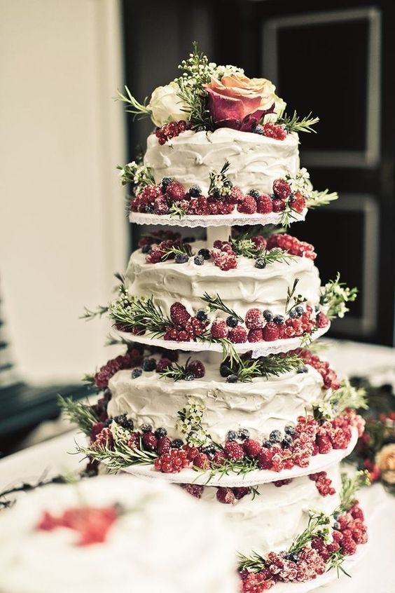 a tiered textural wedding cake topped with evergreens, berries and blooms is a gorgeous and delicious-looking idea