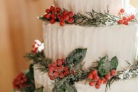 a white textural wedding cake decorated with evergreens, foliage and berries is a very Christmas-like idea