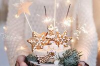 a white winter wedding cake topped with gingerbread cookies, sparklers and marshmallows is a gorgeous idea for winter