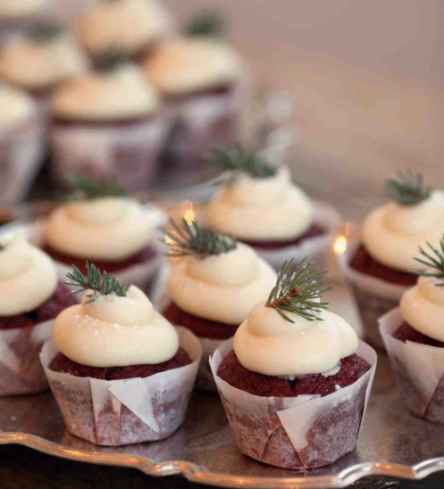 chocolate cupcakes with icing and topped with evergreens for a cozy feel at your wedding
