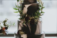 a black and white watercolor wedding cake with greenery branches, thistles and burgundy blooms