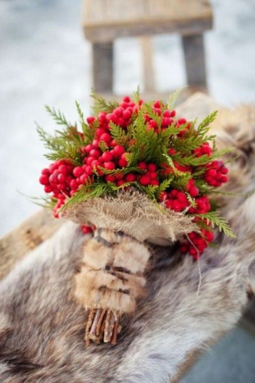a Christmas-inspired bouquet made of berries and fern with burlap and faux fur handle looks very cozy and comforting