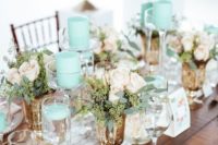 a chic vintage-inspired wedding tablescape with a lace runner, mint candles, neitral linens and pastel blooms