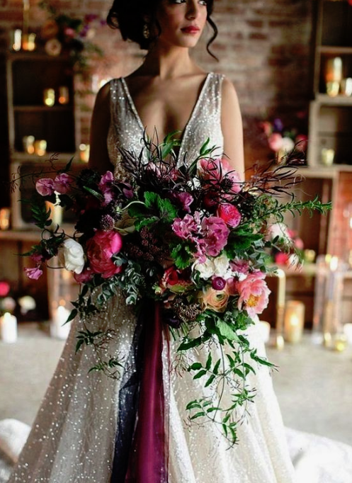 a colorful and lush winter wedding bouquet in pink, purple, withmuch greenery and texture