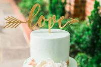 a creative mint wedding cake with a sleek and textural tier, sugar blooms and a glitter calligraphy topper