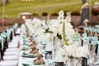 a crispy summer wedding table with maint napkins and mint lemonade in bottles plus neutral blooms