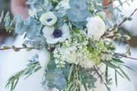 a dimensional pale bouquet with pale eucalyptus, white blooms, greenery for an icy feel