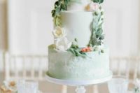 a mint wedding cake with plain and textural tiers, with sugar blooms and leaves