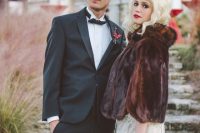 a refined embellished wedding dress paired with a dark faux fur cropped jacket with a collar and short sleeves for a contrasting look