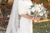 a refined vintage-inspired winter bridal look with a lace A-line wedding dress, a white faux fur stole, a long veil