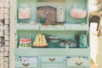 a wedding sweets bar of an oversized mint-colored buffet and lots of tasty sweets