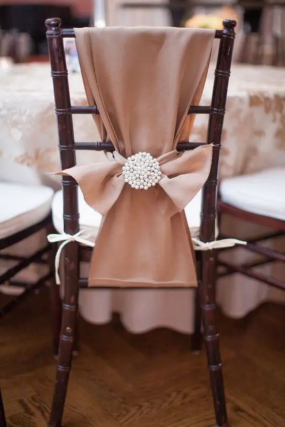 an elegant and chic dusty pink chair cover with pearls is a stylish idea for a refined wedding, it brings both color and interest